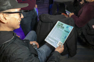 Attendee-checks-out-the-VOCES-program-agenda--scaled